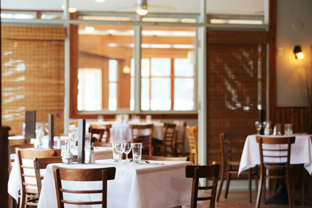 pexels-photo-67468-67468 A serene restaurant interior with wooden chairs and tables set with glasses, ready for dining.